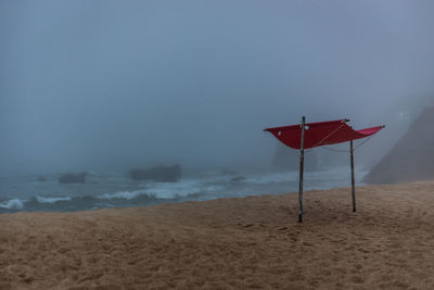 Lifeguard hut on beach against sky