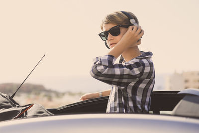 Boy wearing sunglasses listening to music in car