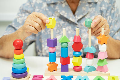 Midsection of woman holding toy blocks on table