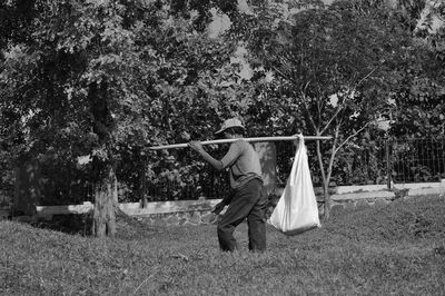 Rear view of woman with umbrella on field