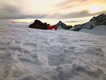 Full length of man lying on snowcapped mountain