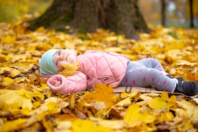 Girl lying on leaves during autumn