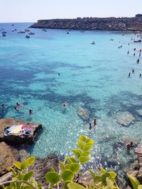 People swimming in sea against sky