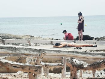 People at beach against sky