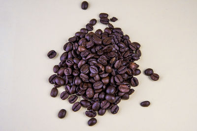 High angle view of coffee beans against white background