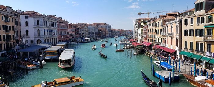 Boats in canal amidst buildings in city