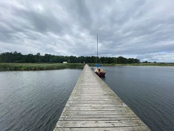 Pier over lake against sky