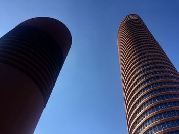 Low angle view of modern building against clear blue sky