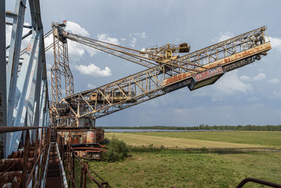 Crane at construction site against sky