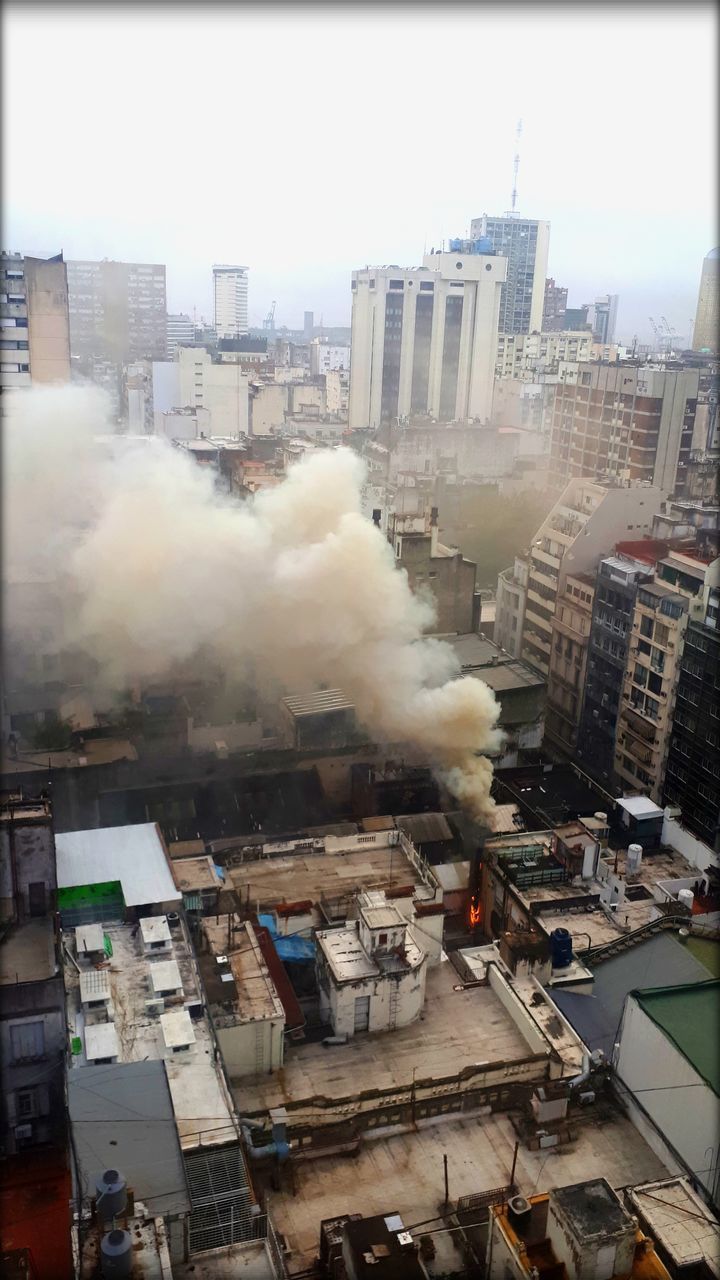 HIGH ANGLE VIEW OF SMOKE EMITTING FROM CHIMNEY AT CITY