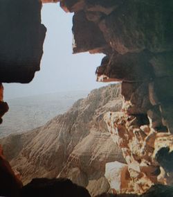 Rock formation on beach against sky