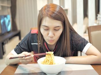 Woman having noodles at home