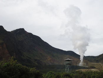 Smoke emitting from volcanic mountain against sky