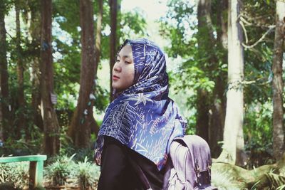 Side view of woman looking away in forest