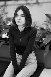 Portrait of young woman sitting outdoors