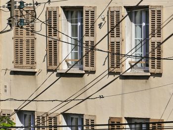 Cables against building during sunny day