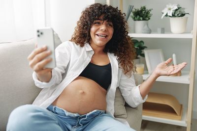 Portrait of young woman using mobile phone at home