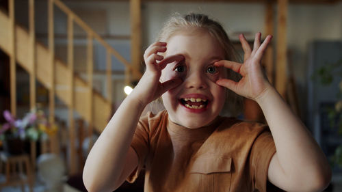 Portrait of smiling girl making face at home