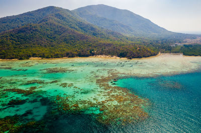 Scenic view of sea and mountains against sky