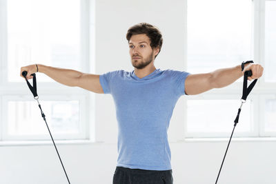 Portrait of young man standing against wall