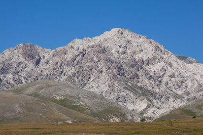 Scenic view of mountains against clear blue sky