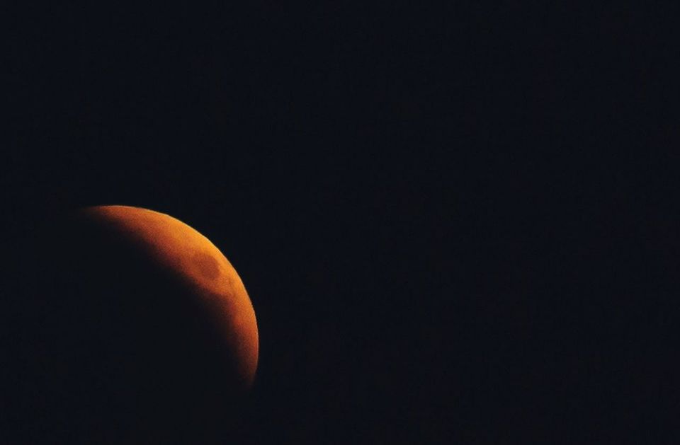 CLOSE-UP OF MOON OVER DARK BACKGROUND