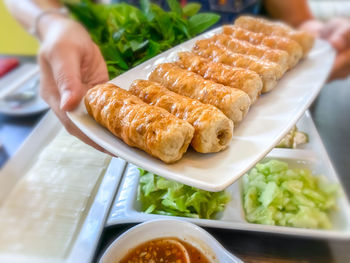 Close-up of hand holding food on table