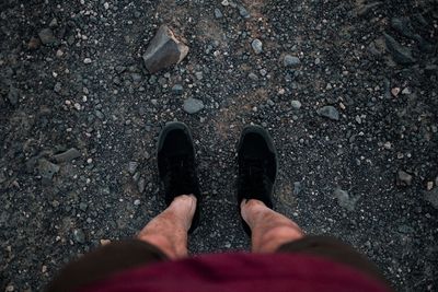 Low section of man standing on field