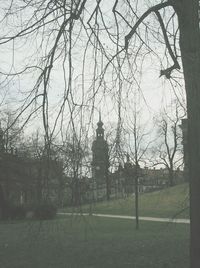 Built structure with bare trees in foreground