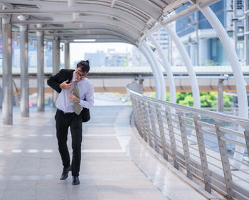 Mid adult businessman walking on elevated walkway