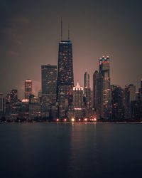 Illuminated buildings against sky at night