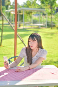 Portrait of young woman sitting on field