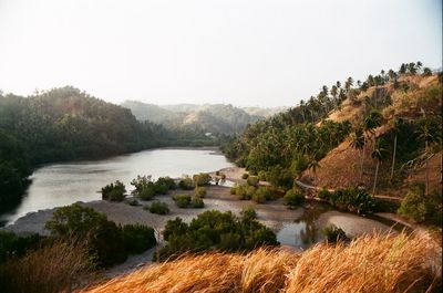 Scenic view of river and mountains against clear sky
