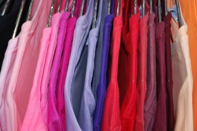 Multi colored clothes hanging in store for sale