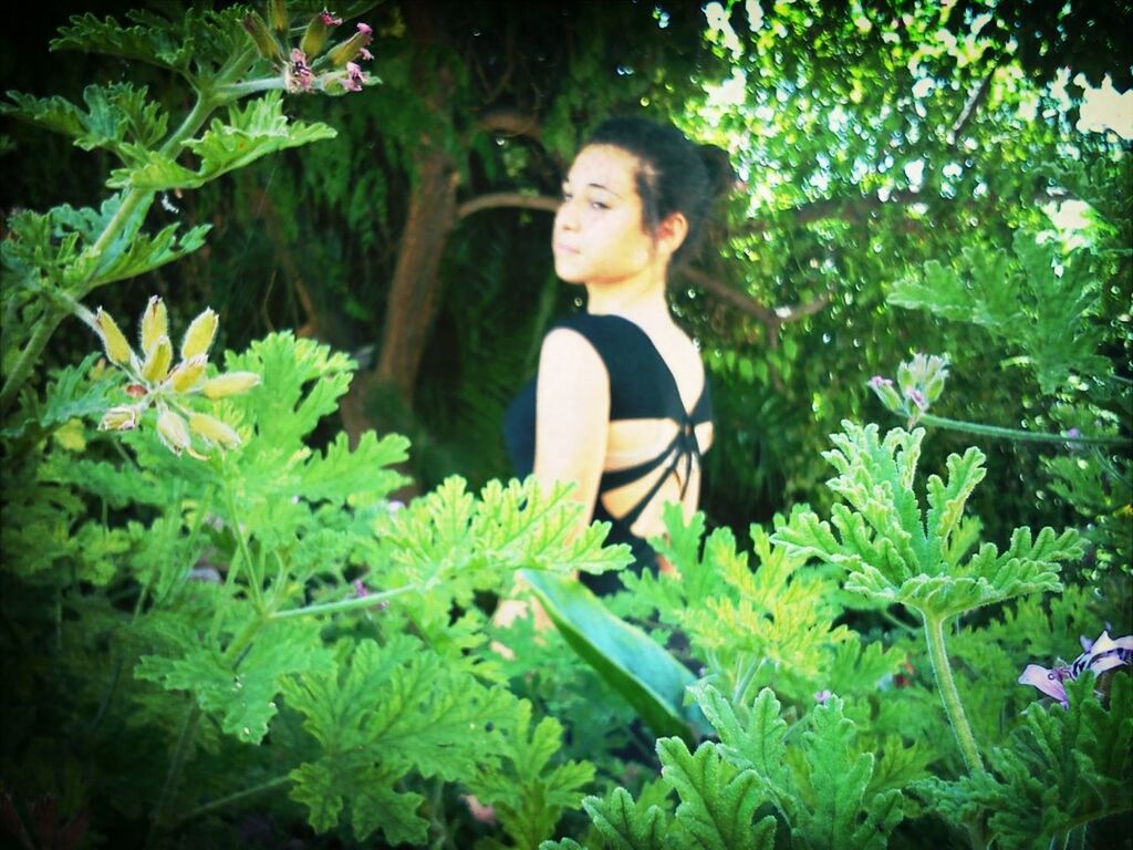 young adult, person, lifestyles, portrait, casual clothing, plant, young women, leisure activity, green color, looking at camera, growth, leaf, front view, full length, smiling, tree, sitting, standing