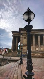 Low angle view of street light against cloudy sky