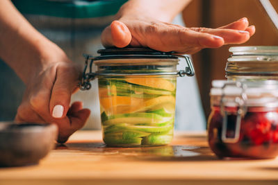 Midsection of man preparing food in glass jar on table