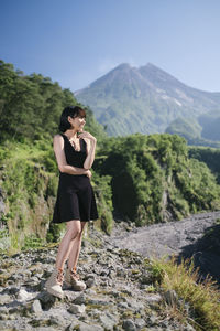 Woman standing on land against mountains