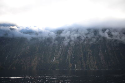 Scenic view of lake by mountains against sky