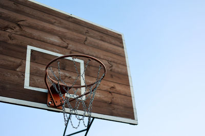 Basketball hoop, metal net and wooden backboard for game on blue sky background. basketball court 