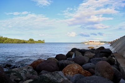 Rocks by sea against sky