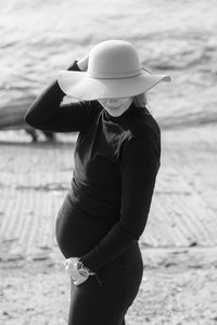 Portrait of a beautiful young pregnant woman in a black turtleneck and black tight skirt