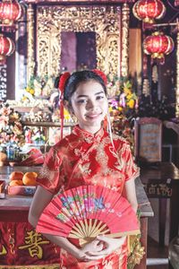 Portrait of young woman holding flowers in market