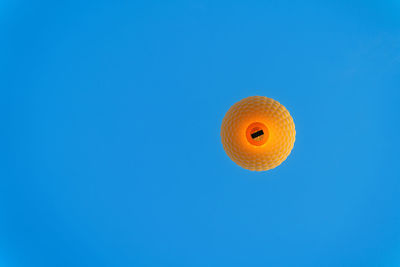 Low angle view of orange against blue sky