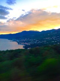 Scenic view of landscape against dramatic sky during sunset