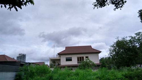 Houses against cloudy sky