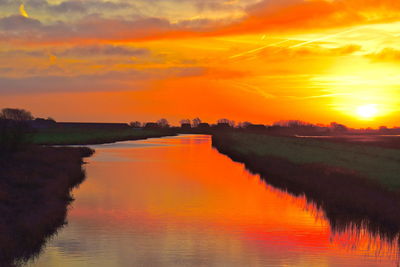 Scenic view of lake against orange sky