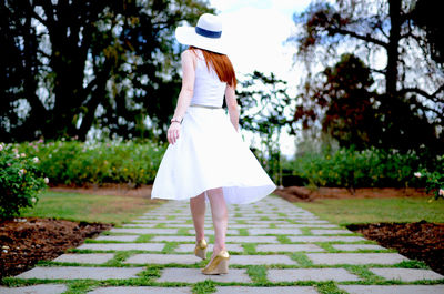 Rear view of woman walking on umbrella