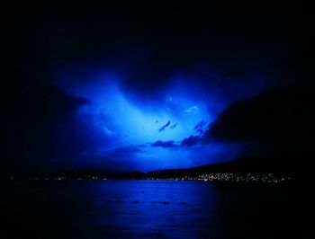 Lightning over sea against sky at night