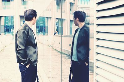 Businessman standing by office building in city